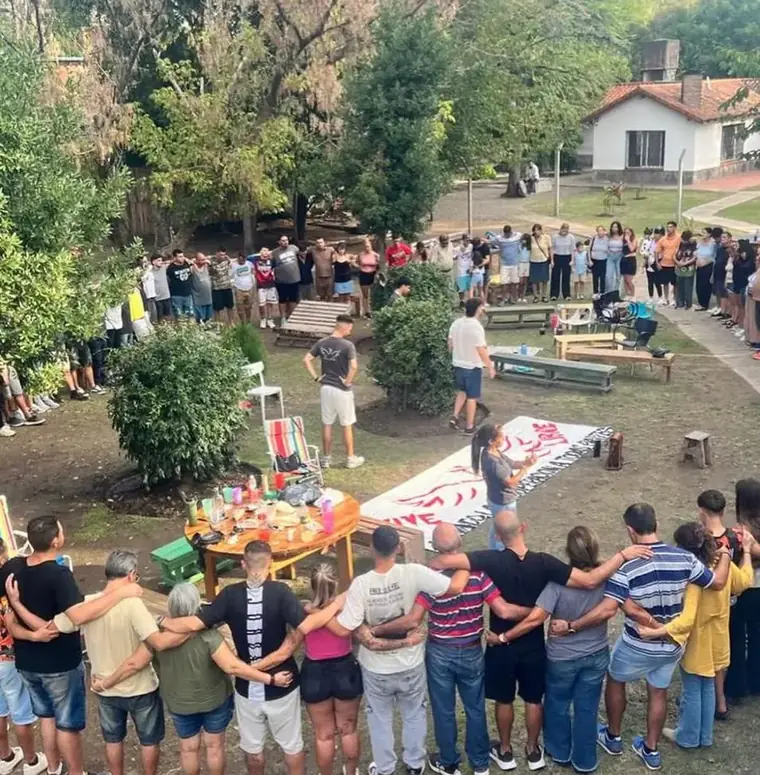 Ronda de pacientes y familias abrazados en el parque de la comunidad terapéutica