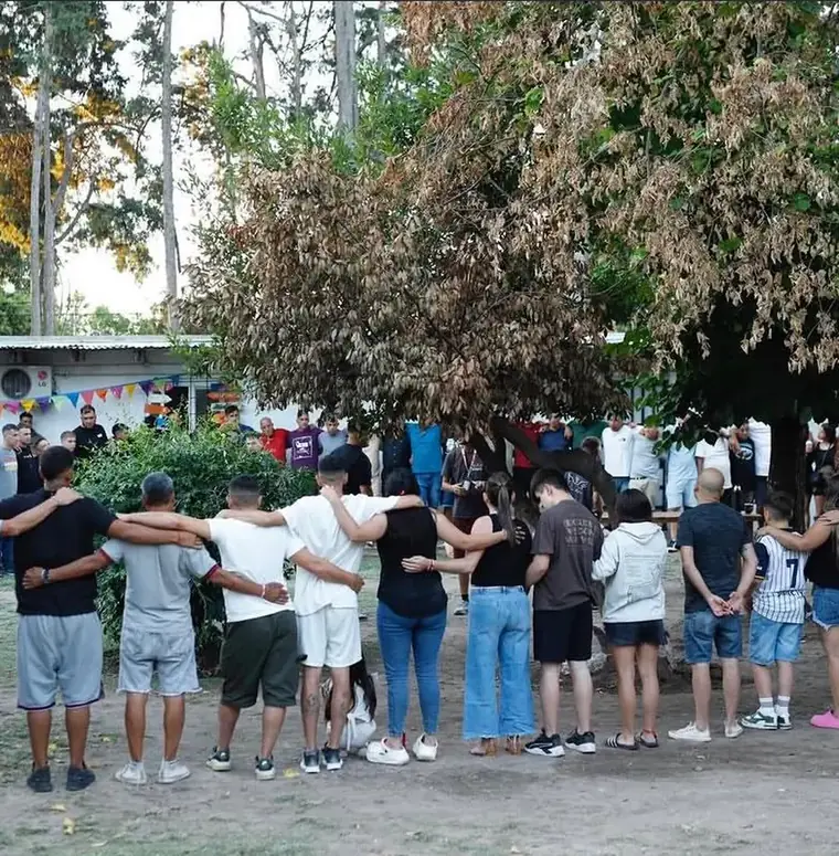 Pacientes abrazados en ronda durante una actividad grupal en el parque